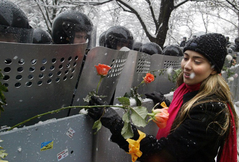 Protestor puts a flower in a riot shield during the Orange Revolution in the Ukraine